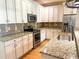 Kitchen features granite counters, stainless appliances, tile backsplash, and white cabinetry at 325 Brook Hollow Ln, Loganville, GA 30052