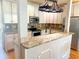 Eat-in kitchen boasts granite countertops, stainless steel appliances, white cabinetry, and stylish lighting at 325 Brook Hollow Ln, Loganville, GA 30052