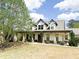 Charming two-story home features a welcoming front porch with decorative columns and a well-manicured lawn at 325 Brook Hollow Ln, Loganville, GA 30052