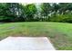 Backyard featuring expansive lawn, trees and a small patio at 945 Navajo Trl, Covington, GA 30016