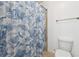Bathroom featuring a toilet, towel rack and shower with a tropical-themed curtain at 241 Haney Rd, Woodstock, GA 30188