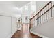 Inviting foyer with hardwood floors, decorative console table, and a staircase with iron railings at 241 Haney Rd, Woodstock, GA 30188