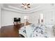 An expansive primary bedroom with hardwood floors, tray ceiling, a tv sitting area, and plenty of natural light at 241 Haney Rd, Woodstock, GA 30188