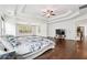 Spacious primary bedroom with hardwood floors, a tray ceiling, large windows, and a sitting area with television at 241 Haney Rd, Woodstock, GA 30188