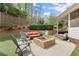 Landscaped backyard featuring a brick fire pit, patio, seating area, and retaining wall with lush greenery at 383 Indian Hills Trl, Marietta, GA 30068