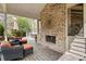 Covered backyard deck with a fireplace, outdoor seating, and a view of the well-maintained yard at 383 Indian Hills Trl, Marietta, GA 30068