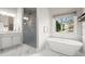 Bright bathroom with a soaking tub, a walk-in glass shower, and a large window with neighborhood view at 383 Indian Hills Trl, Marietta, GA 30068