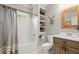 Well-lit bathroom with a shower-tub combo, rustic wood vanity, and decorative shelves at 383 Indian Hills Trl, Marietta, GA 30068