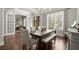 Open dining room with a dark wood table set, large window, and sliding barn doors to an office at 383 Indian Hills Trl, Marietta, GA 30068