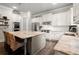 This kitchen offers an island with bar seating, stainless steel appliances, white cabinets, and stone countertops at 383 Indian Hills Trl, Marietta, GA 30068