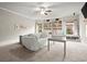 Spacious living room featuring large built in shelves and decorative wall moulding and neutral tones at 383 Indian Hills Trl, Marietta, GA 30068