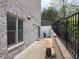 Exterior view of a brick wall, a window, and a narrow side yard with concrete flooring at 383 Indian Hills Trl, Marietta, GA 30068