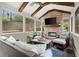 Cozy sunroom featuring wood beams, brick fireplace, and comfortable seating, perfect for relaxation at 383 Indian Hills Trl, Marietta, GA 30068