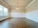 Elegant dining room with wainscoting, hardwood floors, and a stylish chandelier at 5119 Aylesbury Ct, Hoschton, GA 30548