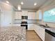 Well-appointed kitchen showcasing granite countertops, stainless steel appliances, white cabinets, and a subway tile backsplash at 5119 Aylesbury Ct, Hoschton, GA 30548