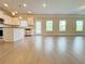 Open-concept living area with wood floors, recessed lighting, and a view into the kitchen at 5119 Aylesbury Ct, Hoschton, GA 30548
