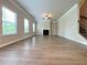 Bright living room features wood flooring, fireplace, crown molding and abundant natural light from many windows at 5119 Aylesbury Ct, Hoschton, GA 30548