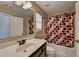 Full bathroom with a dark vanity, decorative shower curtain, and bright lighting at 7130 Rocking Horse Ln, Cumming, GA 30040