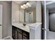 Bathroom features a dark wood vanity with a white sink and updated mirror and lighting at 7130 Rocking Horse Ln, Cumming, GA 30040