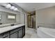 Bright bathroom with a soaking tub, granite counters, large mirror and walk-in shower at 7130 Rocking Horse Ln, Cumming, GA 30040