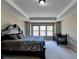 Bright bedroom with tray ceiling, neutral walls, carpeted floors, and a large window at 7130 Rocking Horse Ln, Cumming, GA 30040