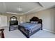 Bedroom with tray ceiling, neutral walls, carpeted floors, and dark wood furniture at 7130 Rocking Horse Ln, Cumming, GA 30040