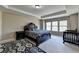 Bright bedroom with tray ceiling, neutral walls, carpeted floors, and a large window at 7130 Rocking Horse Ln, Cumming, GA 30040