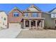 Beautiful two-story brick home with a stone porch and arched entryways at 7130 Rocking Horse Ln, Cumming, GA 30040