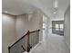 Upstairs hallway with railing, neutral walls, and carpeted flooring at 7130 Rocking Horse Ln, Cumming, GA 30040