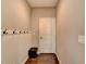 Hallway with hardwood floors, hooks, and a white door at 7130 Rocking Horse Ln, Cumming, GA 30040