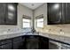 Close up of kitchen with dark wood cabinets, granite countertops, stainless steel appliances, and neutral backsplash at 7130 Rocking Horse Ln, Cumming, GA 30040