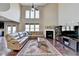 Open-concept living room with a fireplace, high ceilings, and a seamless flow to the kitchen at 7130 Rocking Horse Ln, Cumming, GA 30040