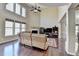 Spacious living room featuring large windows, hardwood floors, and a charming fireplace at 7130 Rocking Horse Ln, Cumming, GA 30040