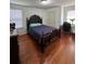 Bedroom showcases a dark wood bedframe and matching vanity, complemented by hardwood floors and bright natural light at 1668 Scenic Pines Dr, Lawrenceville, GA 30044