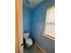 Small toilet room painted blue, with a small window and tile floor at 1668 Scenic Pines Dr, Lawrenceville, GA 30044