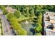 Serene aerial view of a landscaped pond with a fountain surrounded by lush greenery and townhome buildings at 200 River Vista Dr # 713, Atlanta, GA 30339