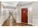 Long hallway with paneled walls and wood floors leading to the unit's front door at 200 River Vista Dr # 713, Atlanta, GA 30339
