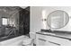 Modern bathroom featuring black marble, a round mirror with sconces, and a shower with custom tile work at 208 Indian Hills Trail, Marietta, GA 30068