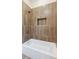 Modern bathroom with a white tub, bronze fixtures and tiled wall niche at 208 Indian Hills Trail, Marietta, GA 30068