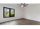 Bright bedroom features a modern ceiling fan, a large window with natural light and stylish gray wood flooring at 208 Indian Hills Trail, Marietta, GA 30068