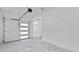 Clean, open garage with concrete floor and white garage door with modern windows allowing lots of light at 208 Indian Hills Trail, Marietta, GA 30068