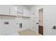 Bright laundry room with a washing machine hookup, cabinets, and access to a closet at 208 Indian Hills Trail, Marietta, GA 30068