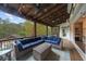 Covered back porch features a vaulted wood ceiling, fan, seating area, and a view of the pool at 332 Chaffin Rd, Roswell, GA 30075