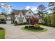 Inviting two-story traditional home with manicured lawn, circular driveway, and a charming front porch at 332 Chaffin Rd, Roswell, GA 30075