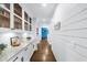Hallway boasts hardwood floors, shiplap walls, and elegant glass-front cabinetry with granite counters at 332 Chaffin Rd, Roswell, GA 30075