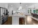 Bright kitchen featuring a large central island, modern lighting fixtures and stainless steel refrigerator at 332 Chaffin Rd, Roswell, GA 30075