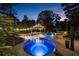 Inviting in-ground pool and spa featuring stone surround, waterfall and cabana with string lights at 332 Chaffin Rd, Roswell, GA 30075