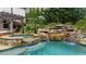 Backyard pool featuring a waterfall feature, a lounge area, and a hammock at 332 Chaffin Rd, Roswell, GA 30075