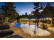 Luxury pool with waterfall feature, outdoor kitchen, covered seating and landscaped surroundings at 332 Chaffin Rd, Roswell, GA 30075