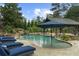 Beautiful backyard pool with a waterfall feature, a lounge area, and a covered cabana at 332 Chaffin Rd, Roswell, GA 30075